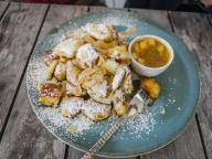 11 May 2024, Hesse, Schmitten: A Kaiserschmarrn pancake on a plate in a restaurant, served with powdered sugar and apple sauce. Photo: Frank Rumpenhorst/dpa