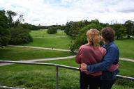25 May 2024, Bavaria, Munich: Nadja (l) and Faustus relax in the English Garden on the Monopteros and look towards the city center with the Frauenkirche and the State Chancellery to recover from their visit to the Metallica concert. On Sunday, the couple attend the rock band