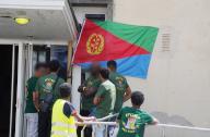 25 April 2024, Baden-Württemberg, Stuttgart: Eritreans stand in front of a building with an Eritrean flag at the entrance. The Eritrea event was peaceful for the time being. Eritreans, who are considered loyal to the regime, celebrated 33 years of independence in Stuttgart on Saturday, as they did elsewhere. Photo: Andreas Rosar/Fotoagentur-Stuttgart/dpa - ATTENTION: Person(s) has/have been pixelated for legal reasons