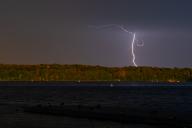25 May 2024, Brandenburg, Potsdam: Lightning discharges at Lake Templin in Potsdam. Photo: Georg Moritz/dpa