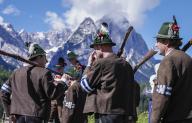 26 May 2024, Bavaria, Garmisch-Partenkirchen: Marksmen in their traditional costumes stand on the sidelines of a festive service for the 27th Alpine regional meeting of mountain marksmen against the backdrop of the Wetterstein mountains. Photo: Uwe Lein/dpa