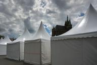 28 May 2024, Thuringia, Erfurt: The towers of the cathedral stand out between the roofs of a tent city on the cathedral square. The construction work for the Catholic Day in Erfurt