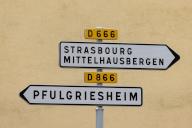 PRODUCTION - 29 May 2024, France, Griesheim Sur Souffel: Two road signs point the way to Strasbourg, Mittelhausbergn and Pfulgriesheim. The special regulations of local law in Alsace and Lorraine state that in the regions that became part of France again after the First World War, German regulations were maintained in many areas of social life. This ranges from hunting rights, religious practice and health insurance to cadastre and associations. The border region is currently struggling to ensure that local law is not undermined in the course of the standardization of rules. Photo: Philipp von Ditfurth/dpa