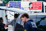 31 May 2024, Baden-Württemberg, Mannheim: Posters from a stand behind police officers on the market square. Police shot down an attacker during an operation on Mannheim