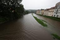 01 June 2024, Thuringia, Greiz: A parking lot (left) on the banks of the "Weiße Elster" river is completely flooded. Numerous floods occurred in eastern Thuringia after heavy thunderstorms. Photo: Bodo Schackow/dpa