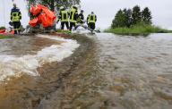 02 June 2024, Baden-Württemberg, Bad Saulgau: Firefighters erect a dam with sandbags against the flood on the Nonnenbach in the Moosheim district. Photo: Thomas Warnack/dpa