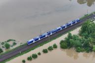 02 June 2024, Baden-Württemberg, Meckenbeuren: The high water of the Schussen river floods parts of Meckenbeuren. A train crosses the higher railroad embankment. (Aerial view with drone) Photo: Felix Kästle/dpa