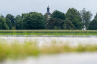 02 June 2024, Bavaria, Baar-Ebenhausen: The steeple of the parish church of St. Martin can be seen behind flooded fields. The district of Pfaffenhofen an der Ilm was hit hard by the floods. Photo: Armin Weigel\/dpa