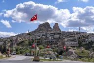 PRODUCTION - 07 May 2024, Turkey, Uchisar: Turkish flags fly in front of the town of Uchisar in the Göreme National Park. The landscape, which is a UNESCO World Heritage Site, is characterized by striking tuff formations known as fairy chimneys. Photo: Jens Kalaene/dpa