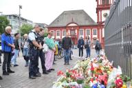 03 June 2024, Baden-Württemberg, Mannheim: Numerous people, including police officers, stand in front of candles and flowers laid down in the immediate vicinity of the crime scene. On Friday morning, a man injured six men, including the police officer, in an attack on the market square in the city center during an event organized by the Islam-critical movement Pax Europa. The 29-year-old succumbed to his injuries on Sunday afternoon. The attacker stabbed the officer several times in the head. The perpetrator