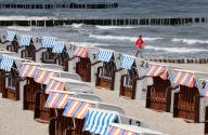 03 June 2024, Mecklenburg-Western Pomerania, Kühlungsborn: Beachgoers on the Baltic Sea sit in the lee next to a beach chair. There is still no summer or beach weather in sight. Photo: Bernd Wüstneck/dpa