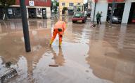 03 June 2024, Baden-Württemberg, Rudersberg: A helper works on a muddy road after a storm. Photo: Bernd Weißbrod/dpa