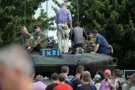 17 June 2023, Brandenburg, Brandenburg/Havel: Visitors to the "Bundeswehr Day 2023" in Brandenburg/Havel stand together with soldiers on a Leopard 2 tank. On June 17, 2023, the Bundeswehr will be inviting visitors to its Day of the Bundeswehr at ten locations in Germany. Photo: Michael Bahlo/dpa