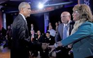 United States President Barack Obama shakes hands with former US Representative Gabby Giffords (Democrat of Arizona) as her husband, retired astronaut Mark Kelly looks on during the commercial break of a live town hall event with CNN