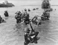Infantrymen wade ashore in neck-deep water from their LCI