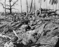 U.S. soldier halts its advance on while a tank blasts Japanese positions on Kwajalein Island. Jan. 31-Feb. 3, 1944. Marshall Islands, World War 2. (BSLOC_2014_10_104)