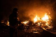 Ukraine firefighters combat a vehicle parking area destroyed by remains of Russian missiles in the aftermath of massive Russia attack on Kyiv, Ukraine, May 16, 2023. Pavlo Petrov/The State Emergency Service of Ukraine handout via EYEPRESS