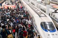 Crowd move on a platform at a railway station in Nanjing in east China\'s Jiangsu province Tuesday, April 30, 2024. Chinese are going to have five days off in a national holiday