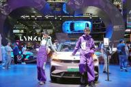 Models pose by a car in the booth of LYNK &amp; CO, a Chinese automaker, during the Beijing Auto Show in Beijing, China Friday, May 03, 2024
