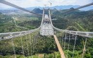 Workers labor at the construction site of a 1,600-meter-long suspension bridge in Xingyi city in southwest China\'s Guizhou province Monday, May 06, 2024