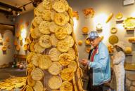 A tourist shops for leavened flatbread known as Nang in the Grand Bazaar in Urumqi in northwest China
