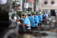 Workers labor in a factory making stainless steel rigging for export in Yangxin county in east China
