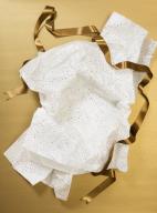 High angle view of crumpled holiday tissue paper and gold ribbon against gold background