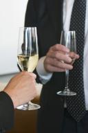 Hands of two men holding champagne flutes