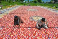 SRINAGAR, INDIA - MAY 16: Artisans give finishing touches to a handmade Kashmiri carpet in the compund of the Hazratbal shrine on May 16, 2024 in Srinagar, India. The artisans claim that it took them 9 years and more than 65,000 man-days for the production of the handmade Kashmiri carpet that would be exported to Gulf. They also claimed that this Kashmiri carpet measuring 72 feet by 40 feet (2880 sq feet) is the Asiaâs largest handmade carpet.(Photo by Waseem Andrabi/Hindustan Times