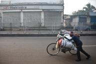 Man, carrying on bike, street, coal, selling to urban dwellers, restaurants, shops, Dhanbad, Bihar, India