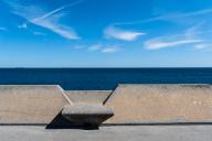 Concrete benches on the Moll de Llevant waterfront promenade, a 4.5 km long promenade for joggers, walkers, cyclists and skaters at the harbour of Tarragona, Spain