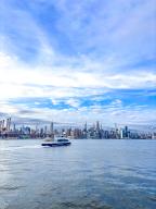 Ferryboat of the New York City Ferry Service on the East River against the backdrop of Manhattan, New York City, USA, North