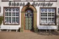 Entrance door of the Swan pharmacy with windows, flower boxes and benches in the city centre of Husum, Nordfriesland district, Schleswig-Holstein, Germany