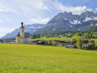 Parish Church of the Holy Cross in Going am Wilden Kaiser, Kaiser Mountains, blue sky and flower meadow, Going am Wilden Kaiser, Tyrol, Austria