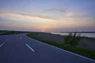 Reservoir South with country road L191 at sunset in Ockholm, district of Nordfriesland, Schleswig-Holstein, Germany