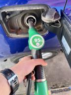 Male hand filling the gas tank of the car. Close-up of man hand supplying gasoline to vehicle. Gasoline rise