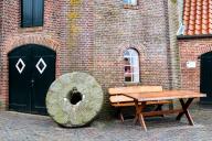 Historic millstone at the old mill in the fishing village of Ditzum, municipality of Jemgum, district of Leer, Rheiderland, East Frisia, Lower Saxony, Germany