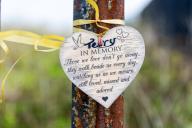 Heart shaped in memory message tied by ribbon to metal post, Felixstowe, Suffolk, England