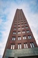 View upwards along the façade of a slender brick tower block, Berlin, Germany