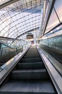Escalator leads into a modern station concourse with an impressive glass roof, Berlin, Germany