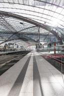 Spacious station concourse with glass roof and reflective surfaces, Berlin Central Station, Berlin, Germany