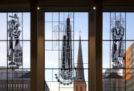 View through the glass front of the main railway station with three pictorial stained glass windows onto St Peters Church, Dortmund, North Rhine-Westphalia, Germany