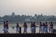 High caste hindus are walking along the lake Bindu, brahmins have performed a hindu ritual, Lingaraj temple in the background, Bhubaneswar, India