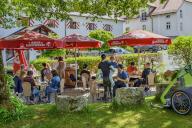 Sunshades and tourists in the beer garden at the Brauereigasthof, Irseer Klosterbräu, Irsee, Bavaria, Germany