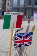 Signs with Italian and English flags show tourists which city tour is taking place in which language, Riga, Latvia
