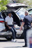 LOUISVILLE, KY - MAY 13: Tiger Woods (USA) talks to a police officer as he changes shoes in the player parking lot following a practice round prior to the 2024 PGA Championship on May 13, 2024, at Valhalla Golf Club in Louisville, Kentucky. (Photo by Joe Robbins\/Icon Sportswire