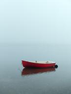 Red rowboat on misty overcast morning