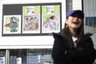 A pedestrian walks past an electric bulletin board that displays images of Dragon Ball at Shinjuku entertainment district of Tokyo, March 11, 2024. World-renowned Japanese manga artist Akira Toriyama, known for works including "Dr. Slump" and "Dragon Ball," died of acute subdural hematoma on March 1. He was 68. JIJI PRESS PHOTO / MORIO TAGA