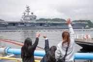 A family watches the aircraft carrier USS Ronald Reagan as it departs the U.S. Navy
