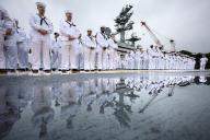 Crew members of the aircraft carrier USS Ronald Reagan gather on the flight deck before departing the U.S. Navy